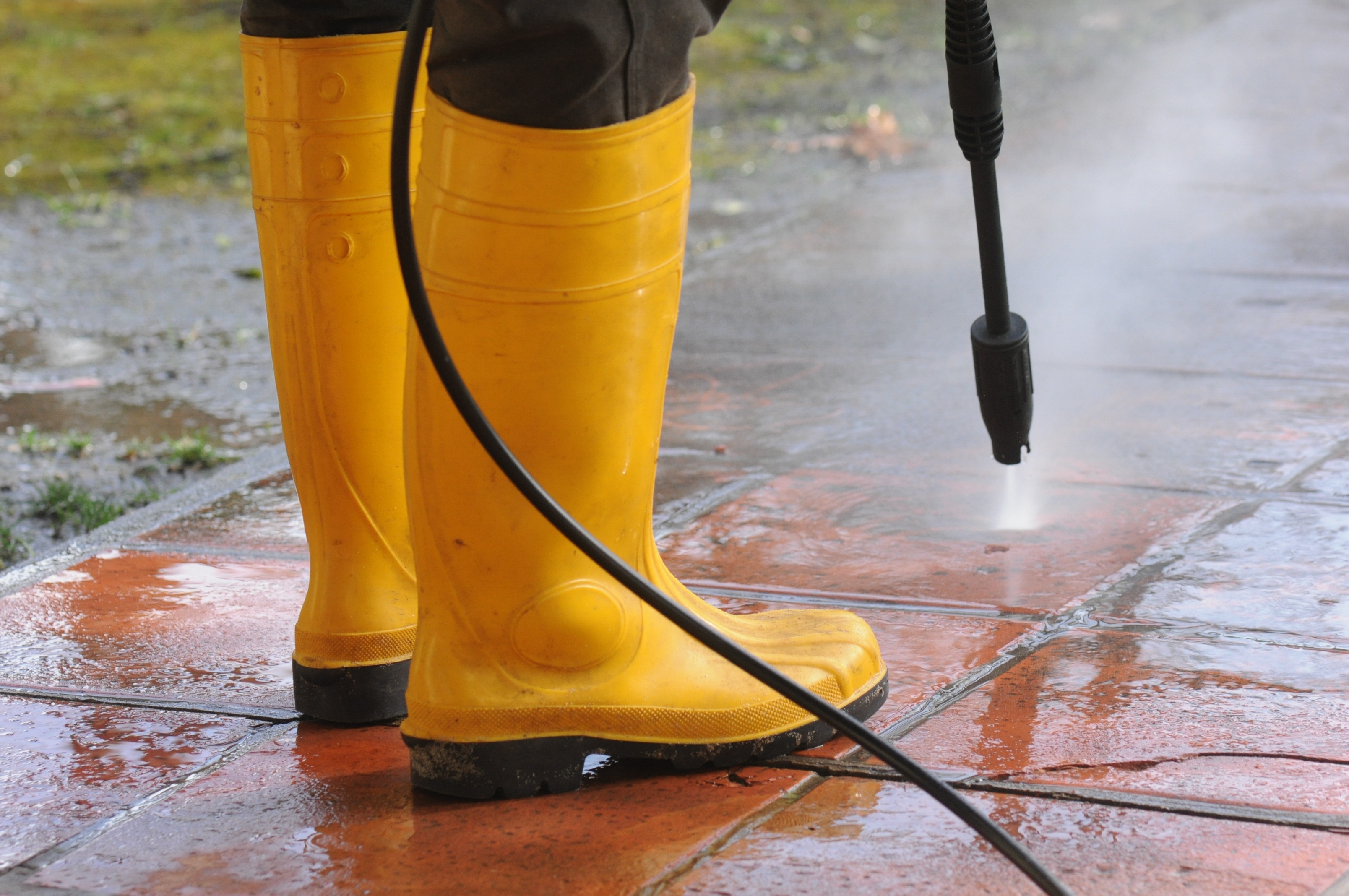 Professional power washing in action with high-pressure equipment and protective gear